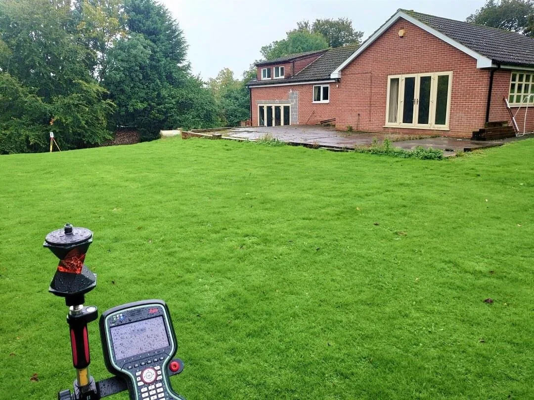 GNSS survey equipment set up on a residential lawn